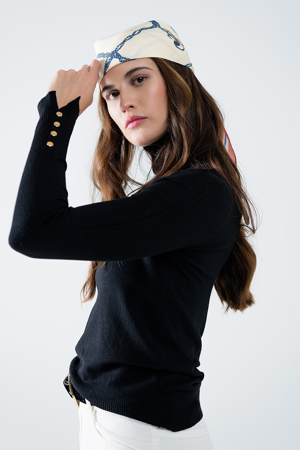 Pull à col roulé noir avec boutons dorés sur le poignet