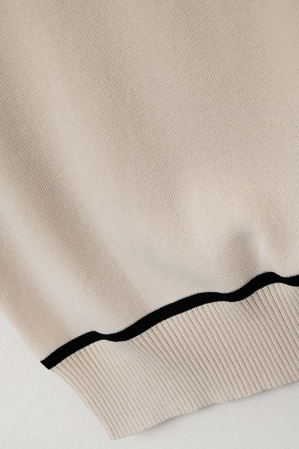 Pull sans manches beige avec détails de lignes noires