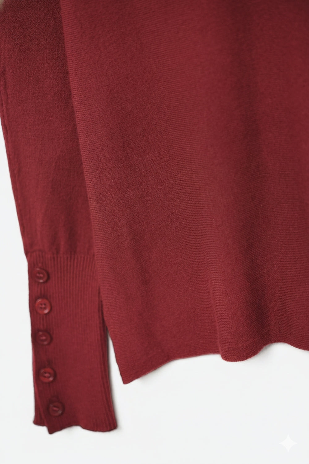 Pull en tricot doux de couleur bourgogne avec détails de boutons sur les manches