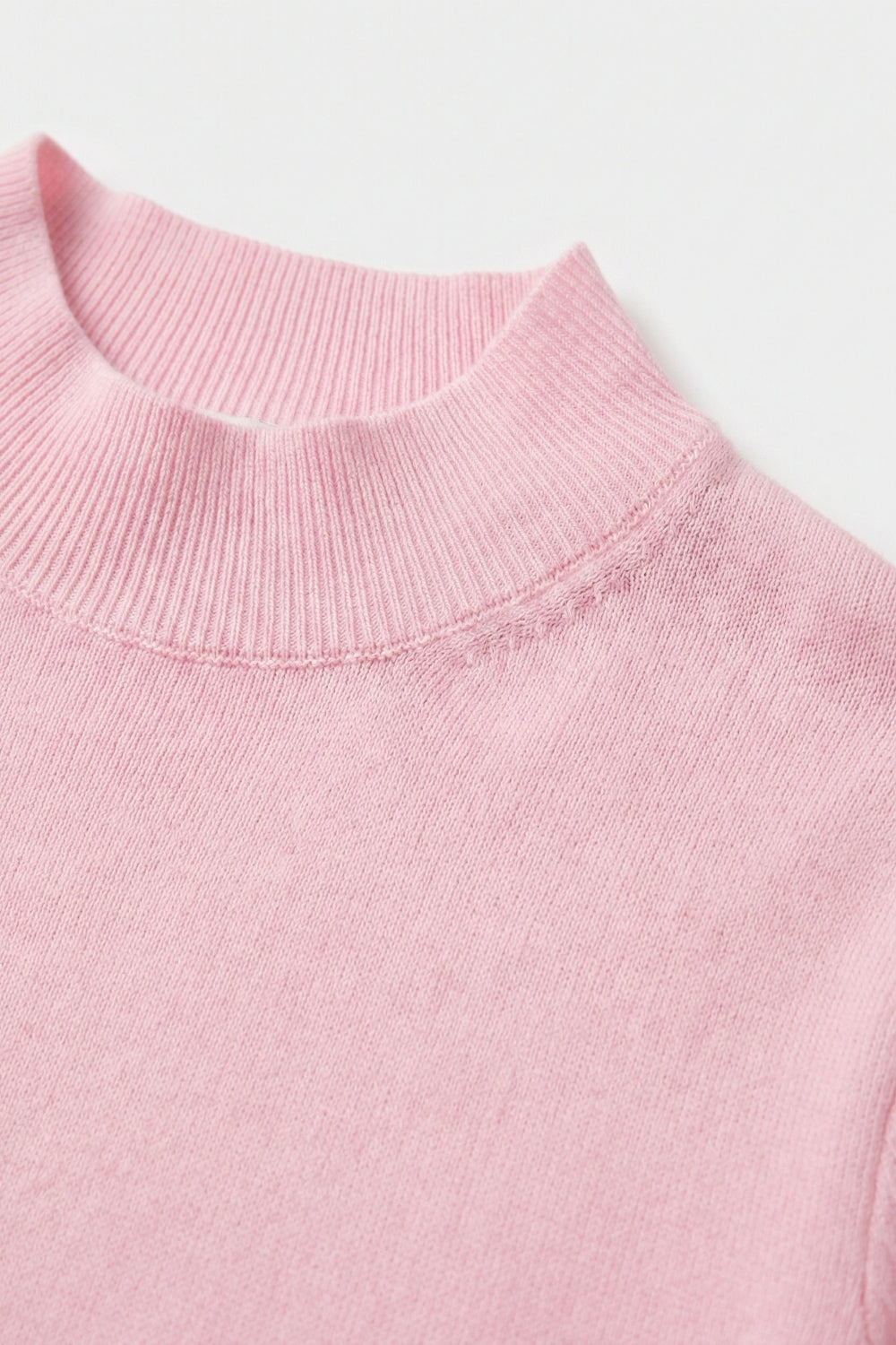 Pull à col roulé rose avec manches courtes ajustées
