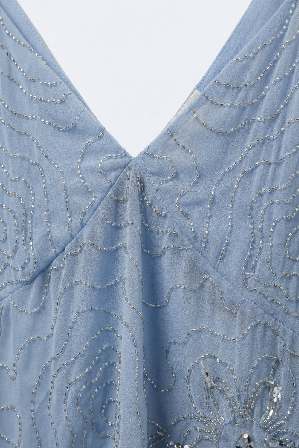 Top à ourlet asymétrique en mousseline bleu clair avec ornement de perles