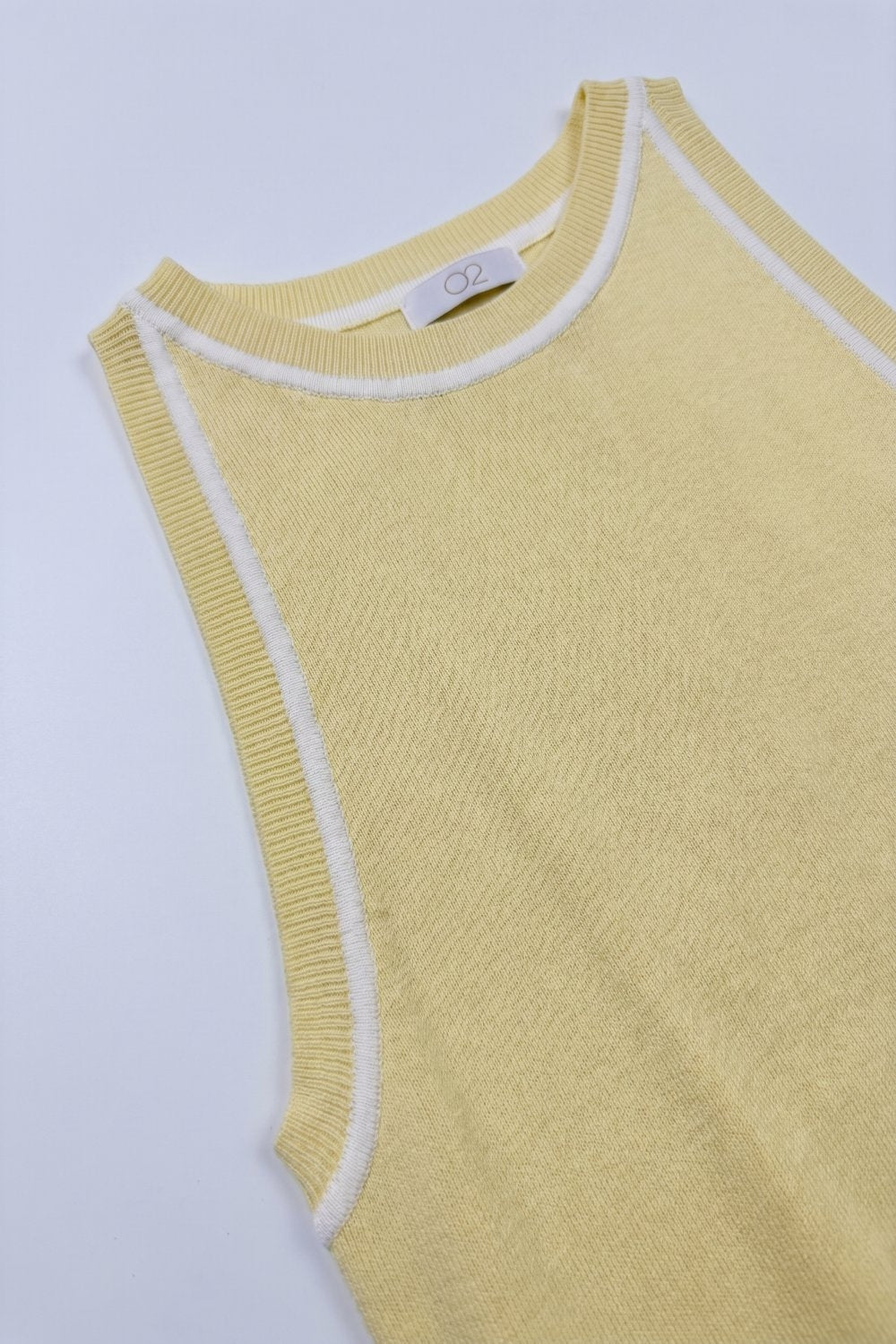 pull tricoté sans manches en jaune beurre avec détails de lignes blanches
