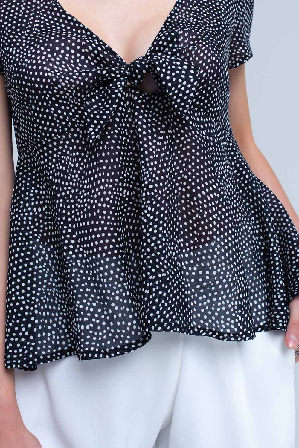 Top noir à pois avec ourlet à volants