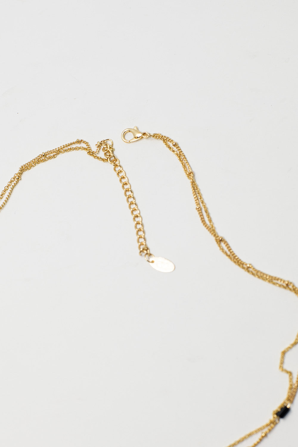 Collier court en or 2 en 1 avec perles noires et pierre marbrée blanche.
