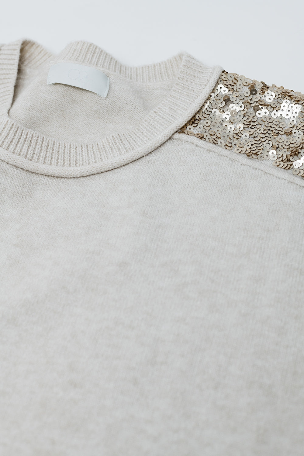 Pull beige à manches longues avec paillettes sur les épaules