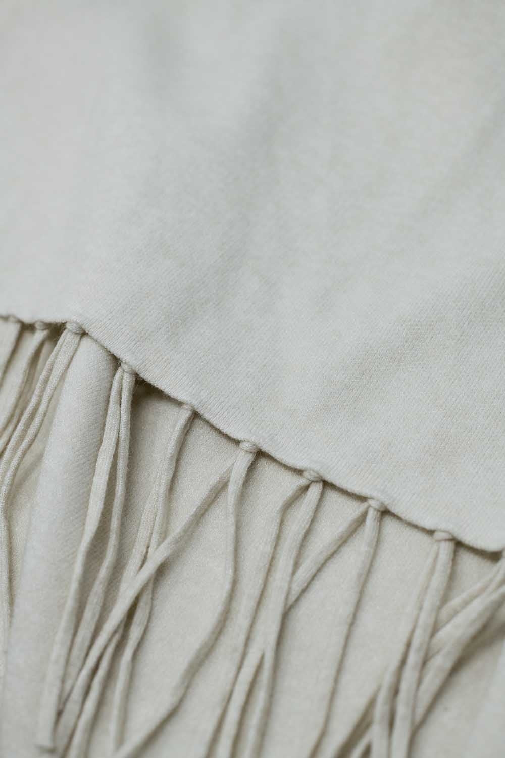 Poncho en tricot doux beige avec franges