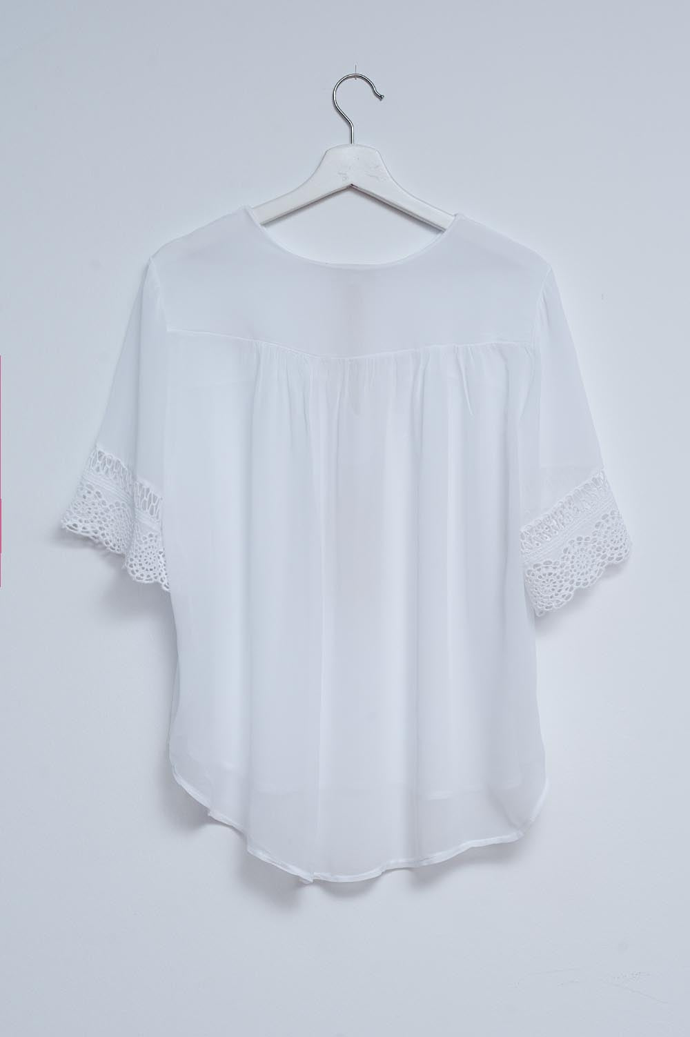 Blouse nouée sur le devant en broderie anglaise blanche