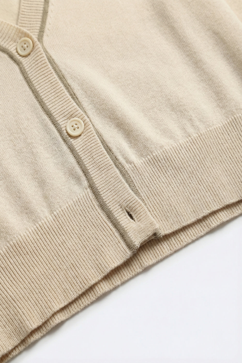 Cardigan en maille fine beige avec bordures contrastées en marron