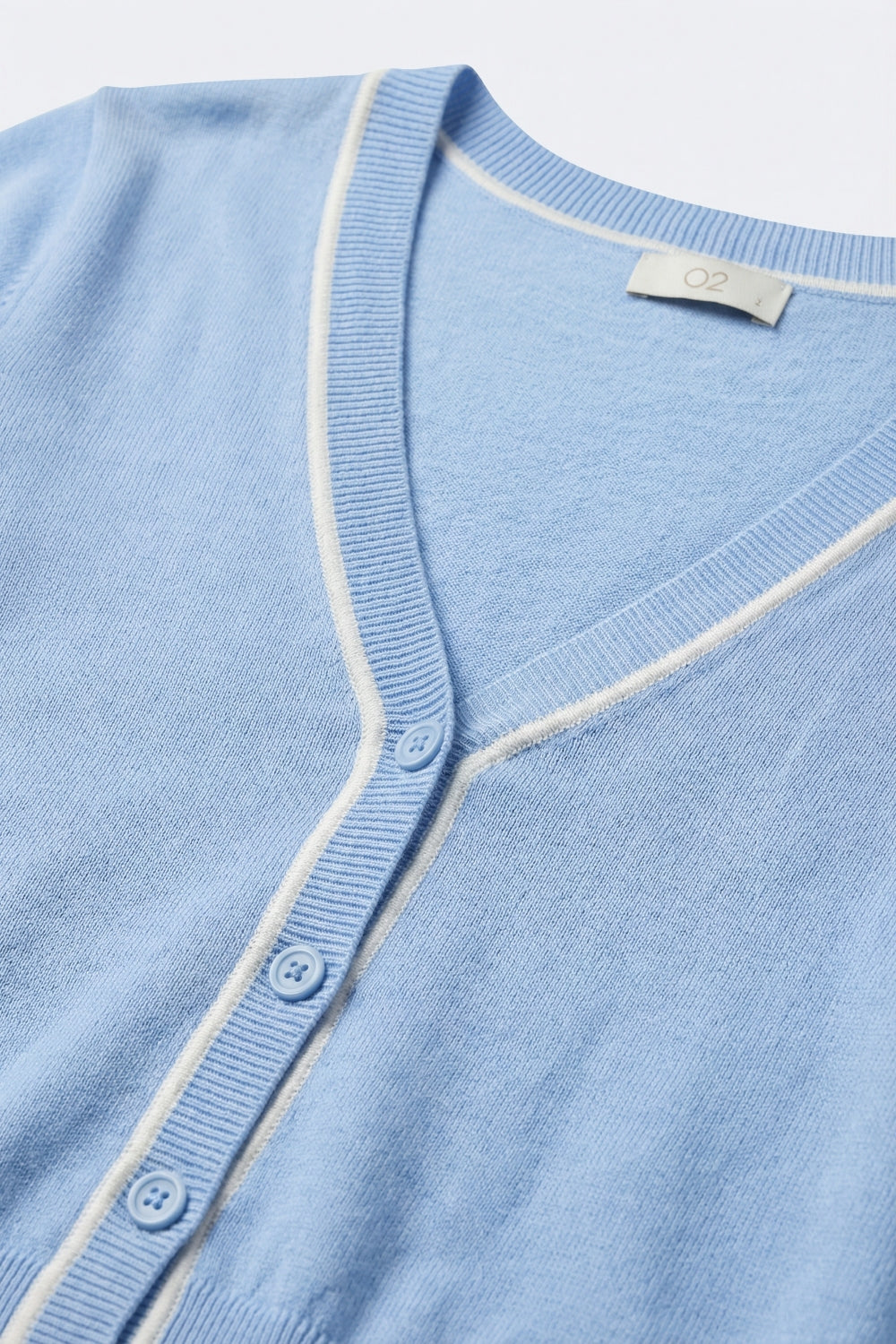 Cardigan en maille fine bleu bébé avec bordure contrastée en blanc