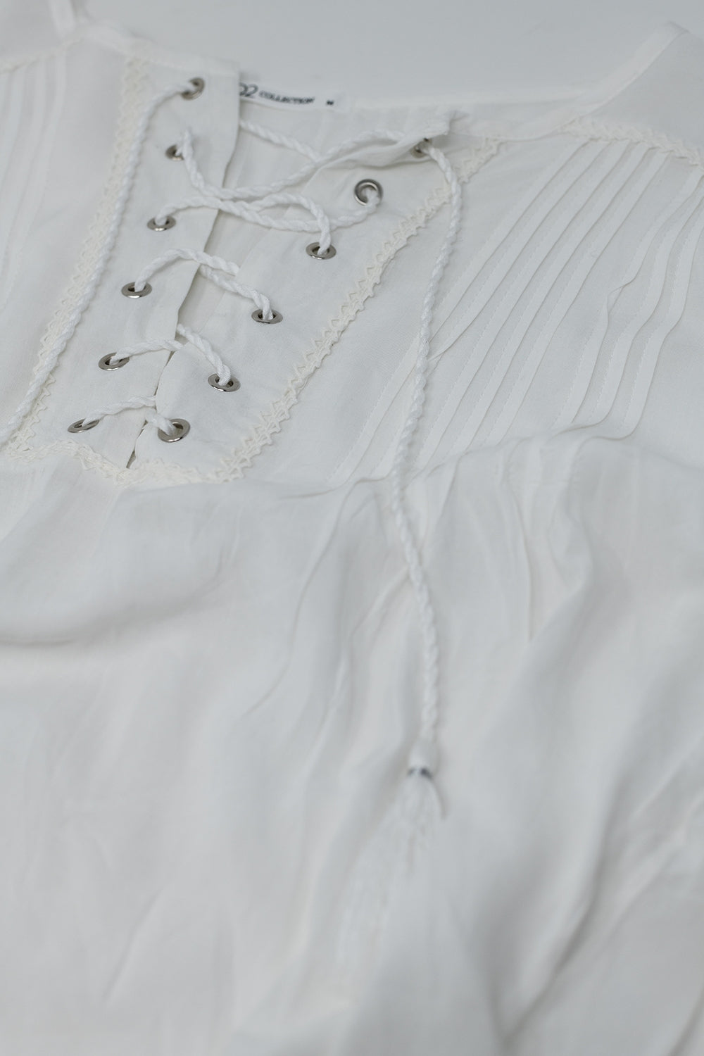 Chemise blanche avec extrémités à glands et fermeture par liens croisés