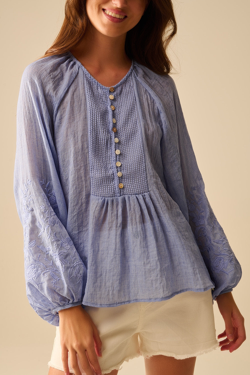 Chemisier en mousseline de soie bleue avec broderies sur les manches