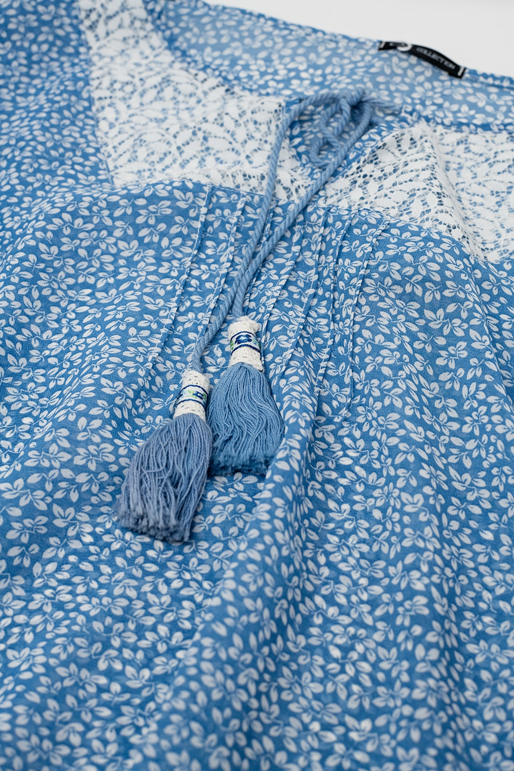 Chemisier en mousseline de soie bleue avec détails en dentelle