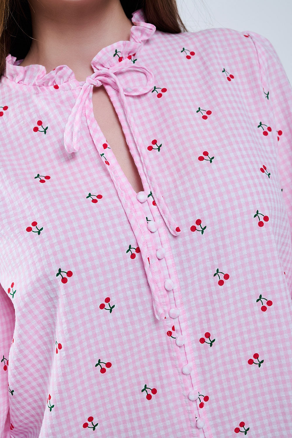 Chemisier rose avec détails de cerises et nœud noué
