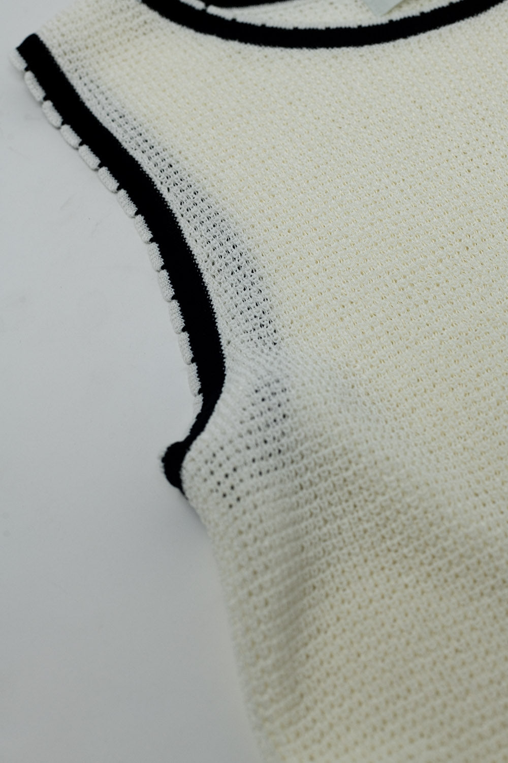 Haut sans manches blanc en pointelle avec détails de bordure noirs et blancs