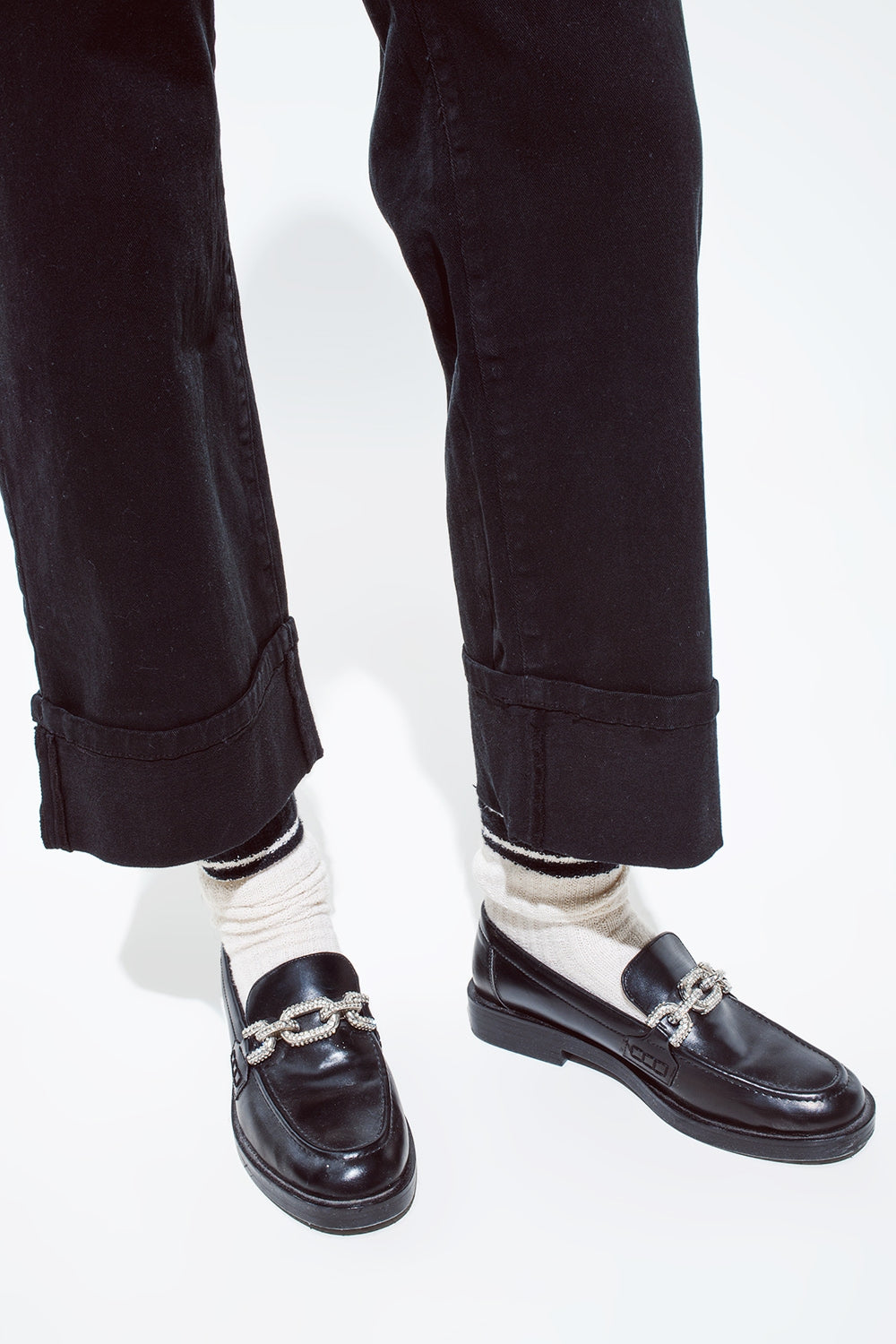Jean droit noir avec les jambes repliées