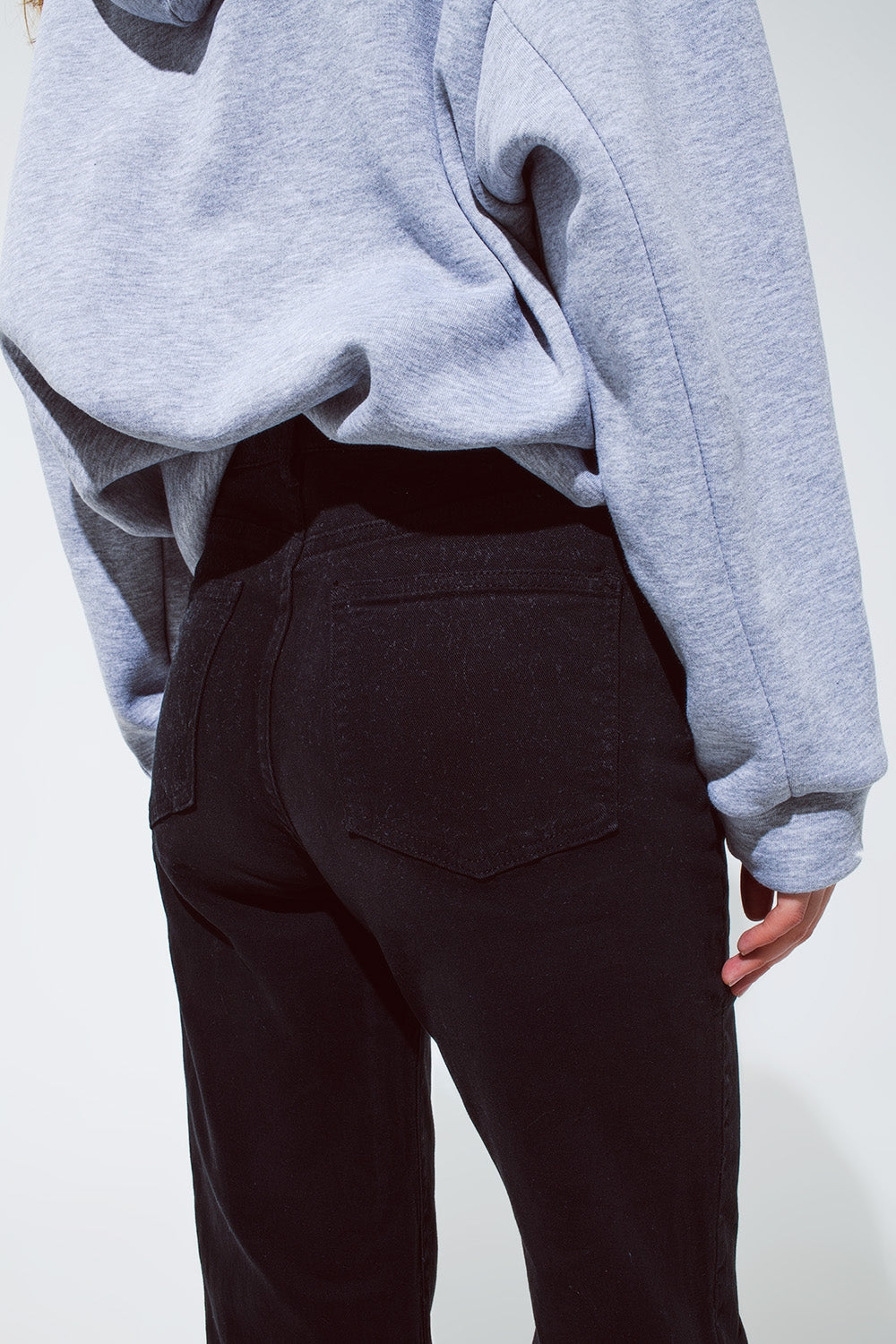 Jean droit noir avec les jambes repliées