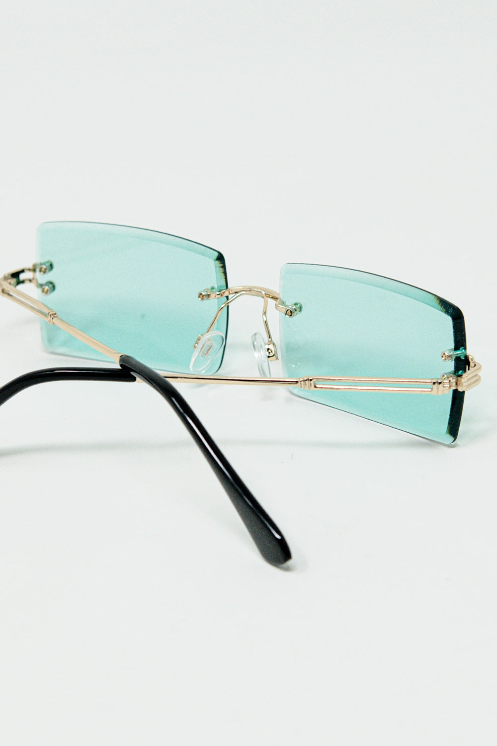 Lunettes de soleil carrées dorées à monture fine et verres turquoise