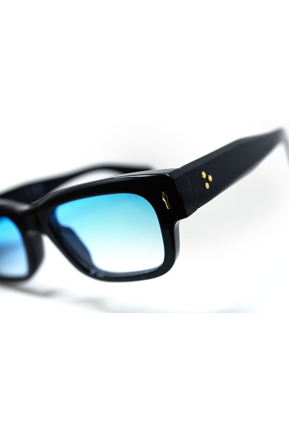 Lunettes de soleil noires à monture ovale avec détails dorés et verre bleu