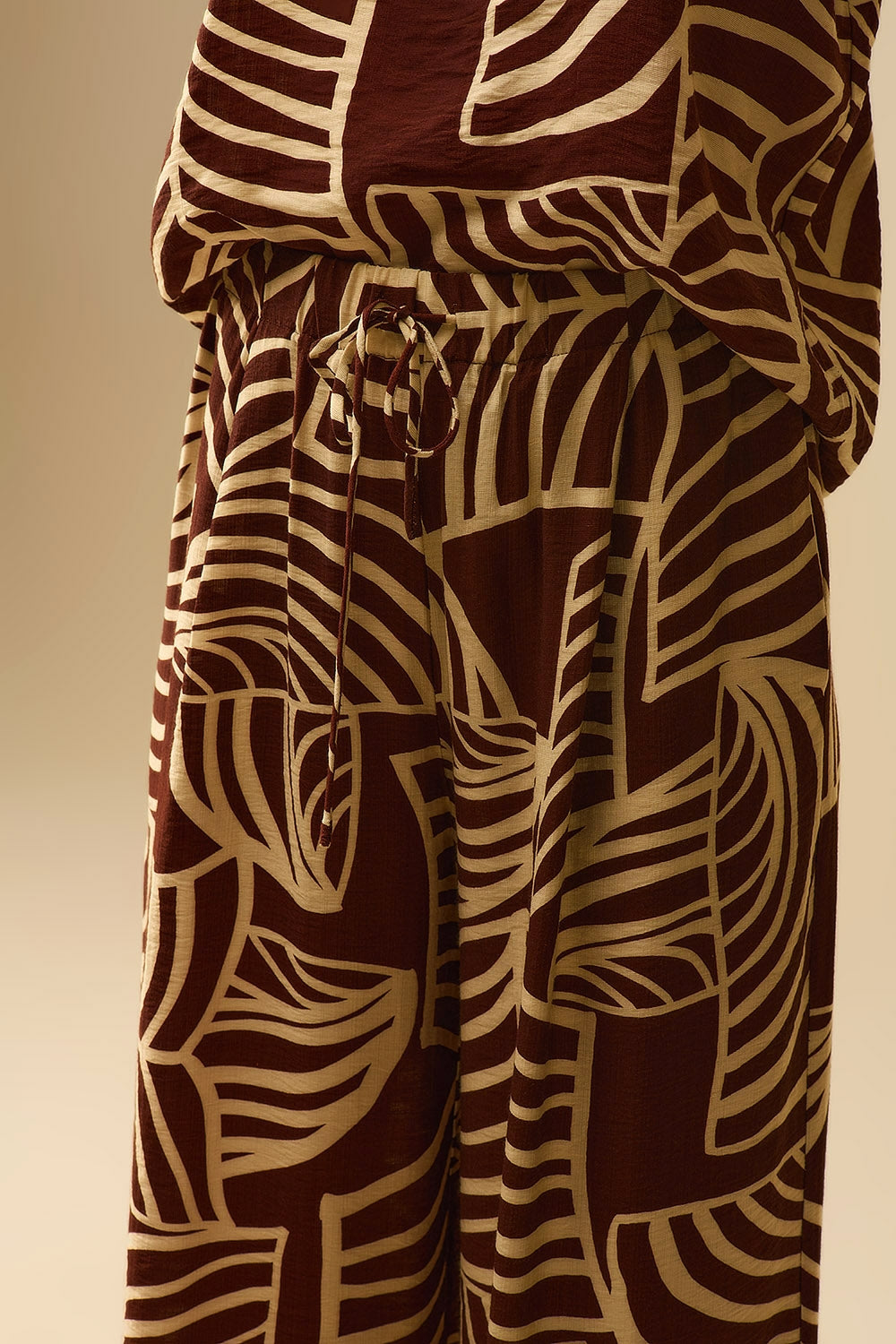 Pantalon large marron avec imprimé feuilles blanches