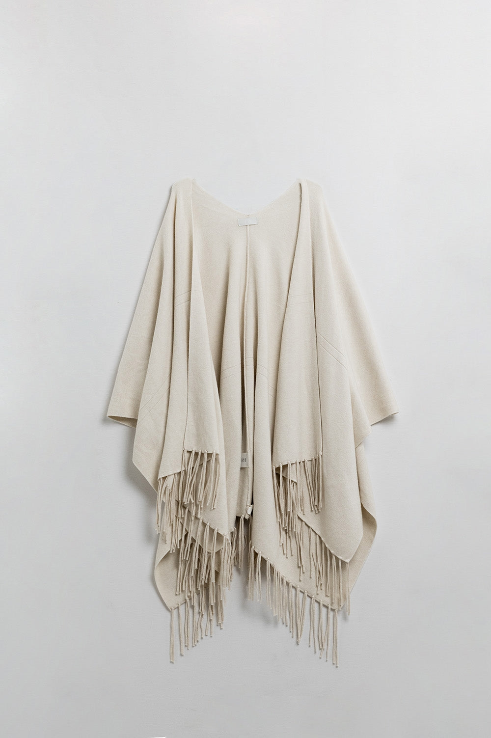 Poncho en tricot doux beige avec franges