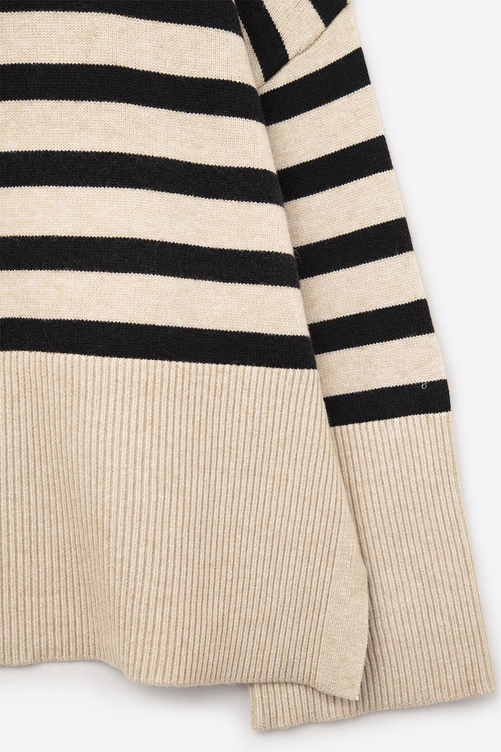Pull beige à col roulé surdimensionné avec des rayures noires et des fentes sur le côté