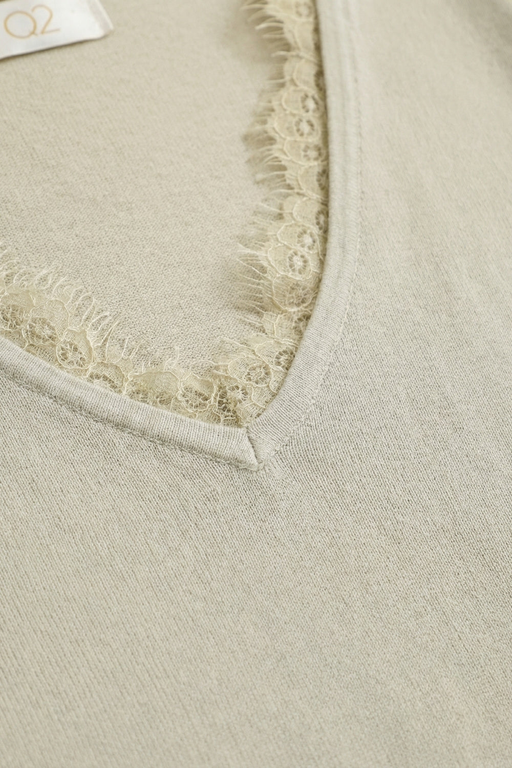 Pull en maille fine et douce avec col en V et bordures en dentelle en beige