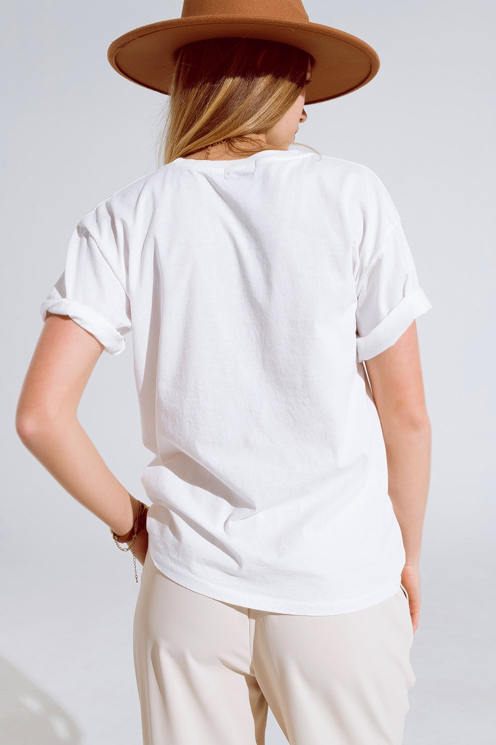 T-shirt crème avec logos de noms célèbres sur le devant