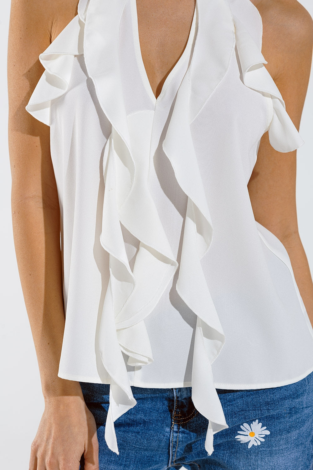 Top blanc sans manches avec détails à volants et col montant