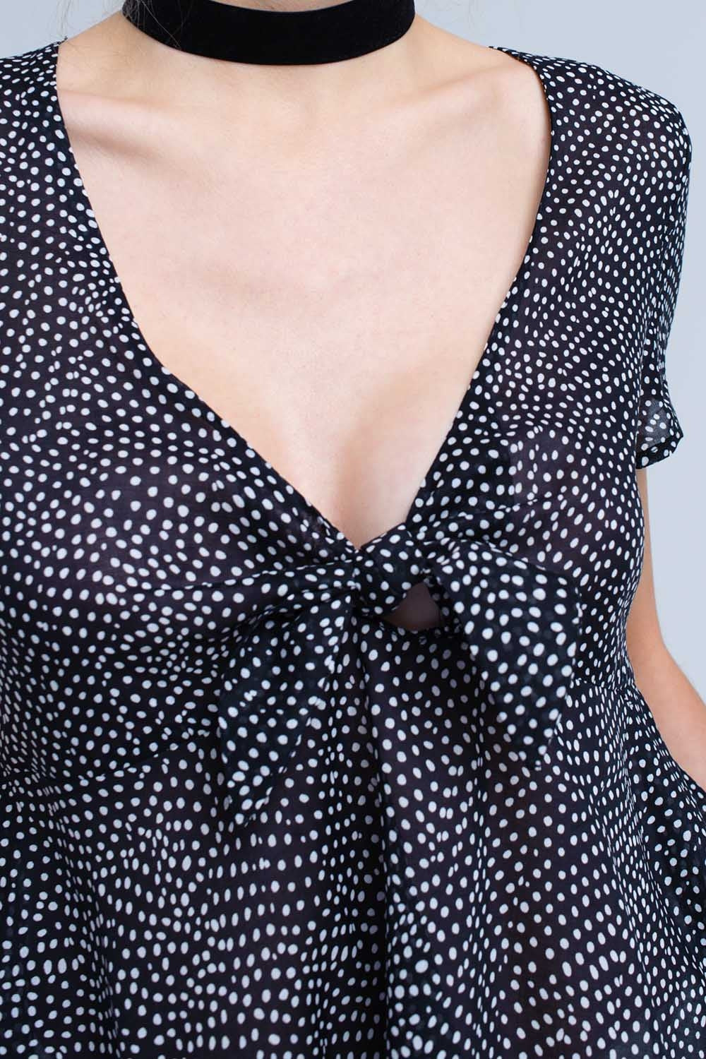 Top noir à pois avec ourlet à volants