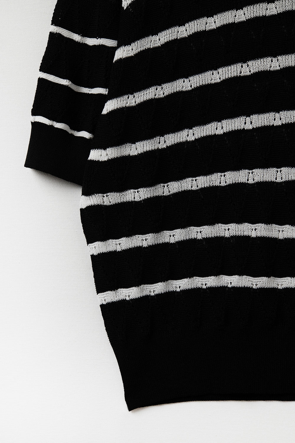 Top noir en tricot ajouré avec manches courtes et rayures blanches