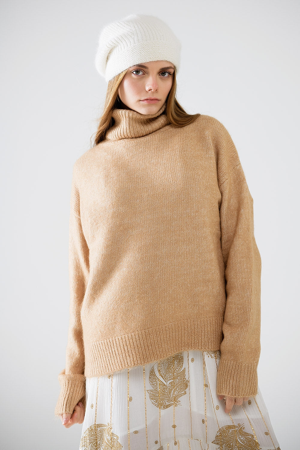 Pull beige à col roulé et manches tombantes