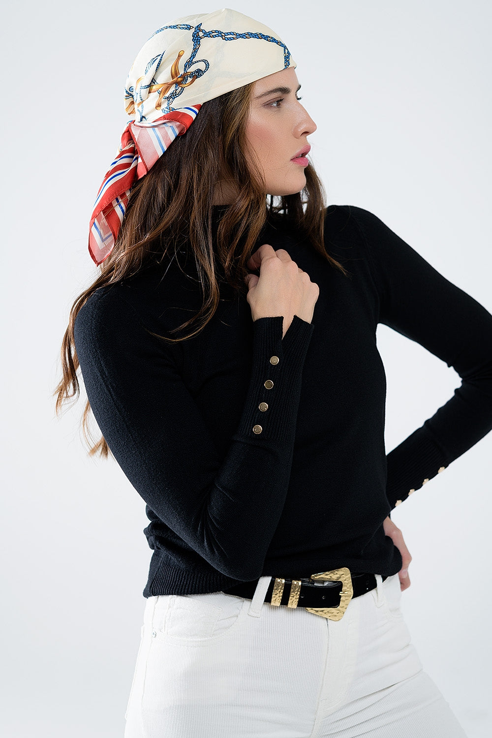 Pull à col roulé noir avec boutons dorés sur le poignet