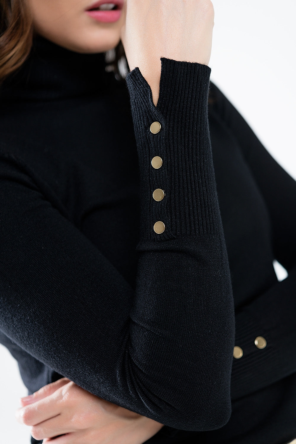 Pull à col roulé noir avec boutons dorés sur le poignet