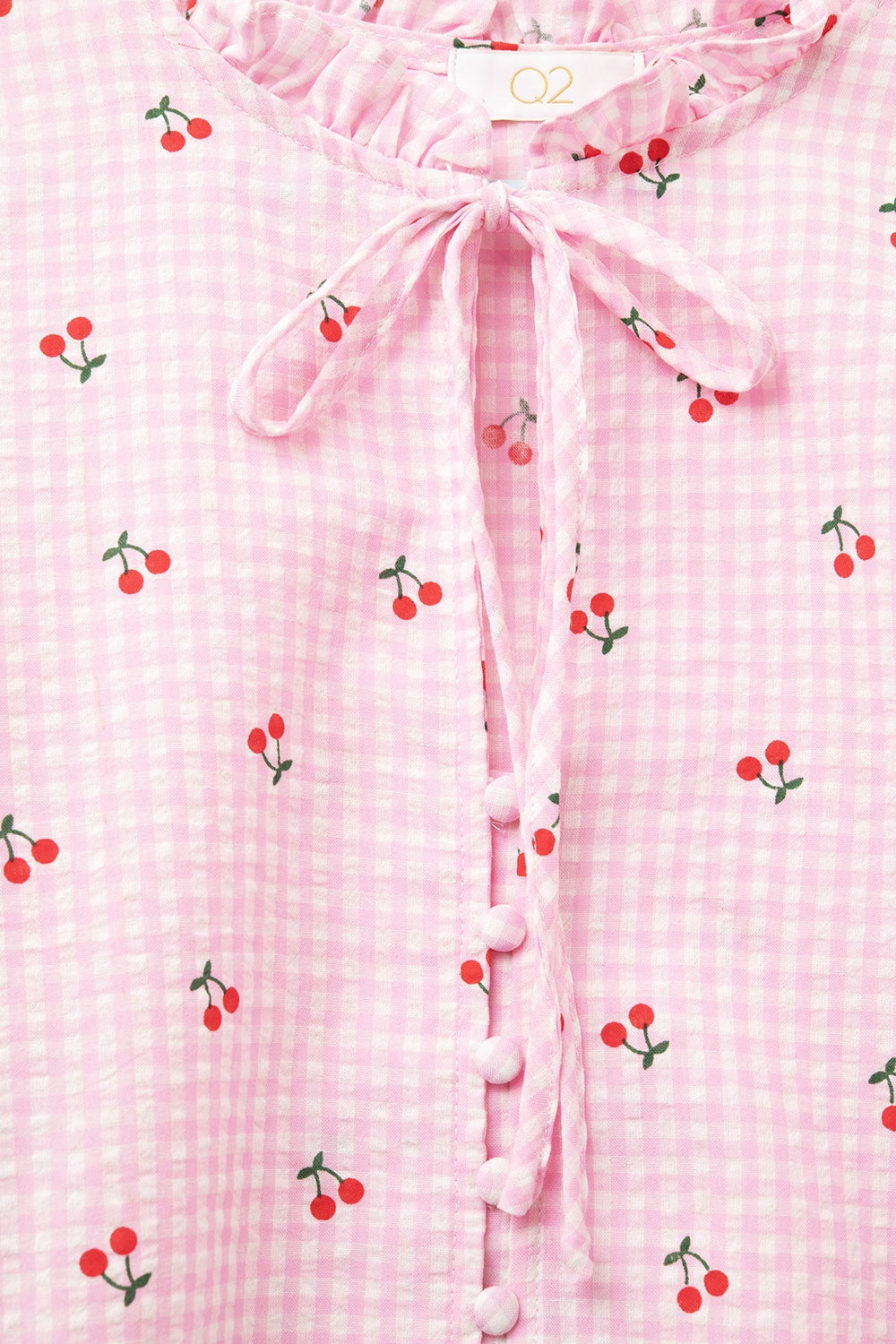 Chemisier rose avec détails de cerises et nœud noué
