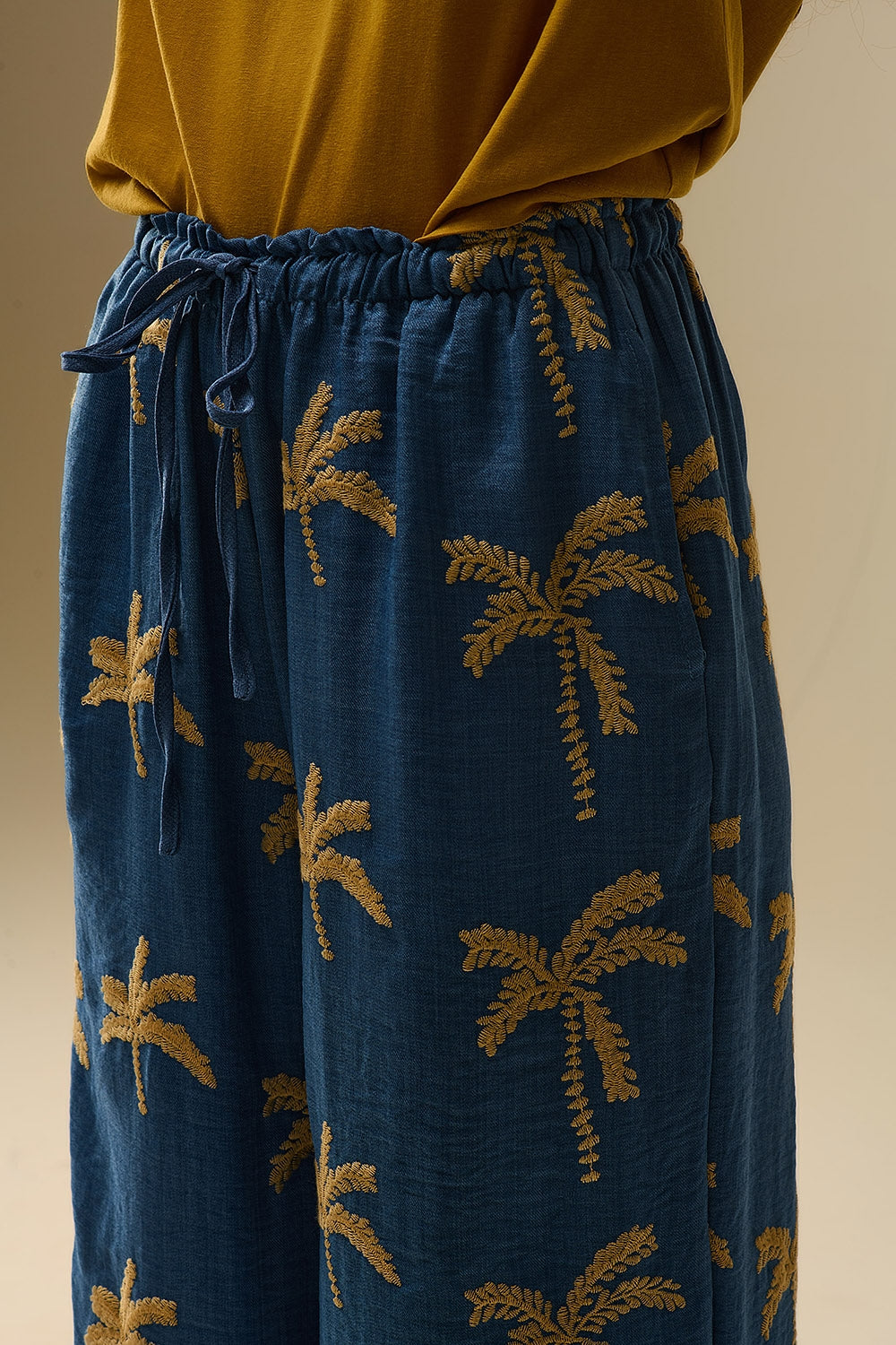 Pantalon large bleu avec broderie de palmier beige