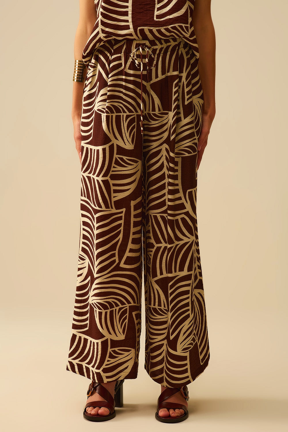 Pantalon large marron avec imprimé feuilles blanches