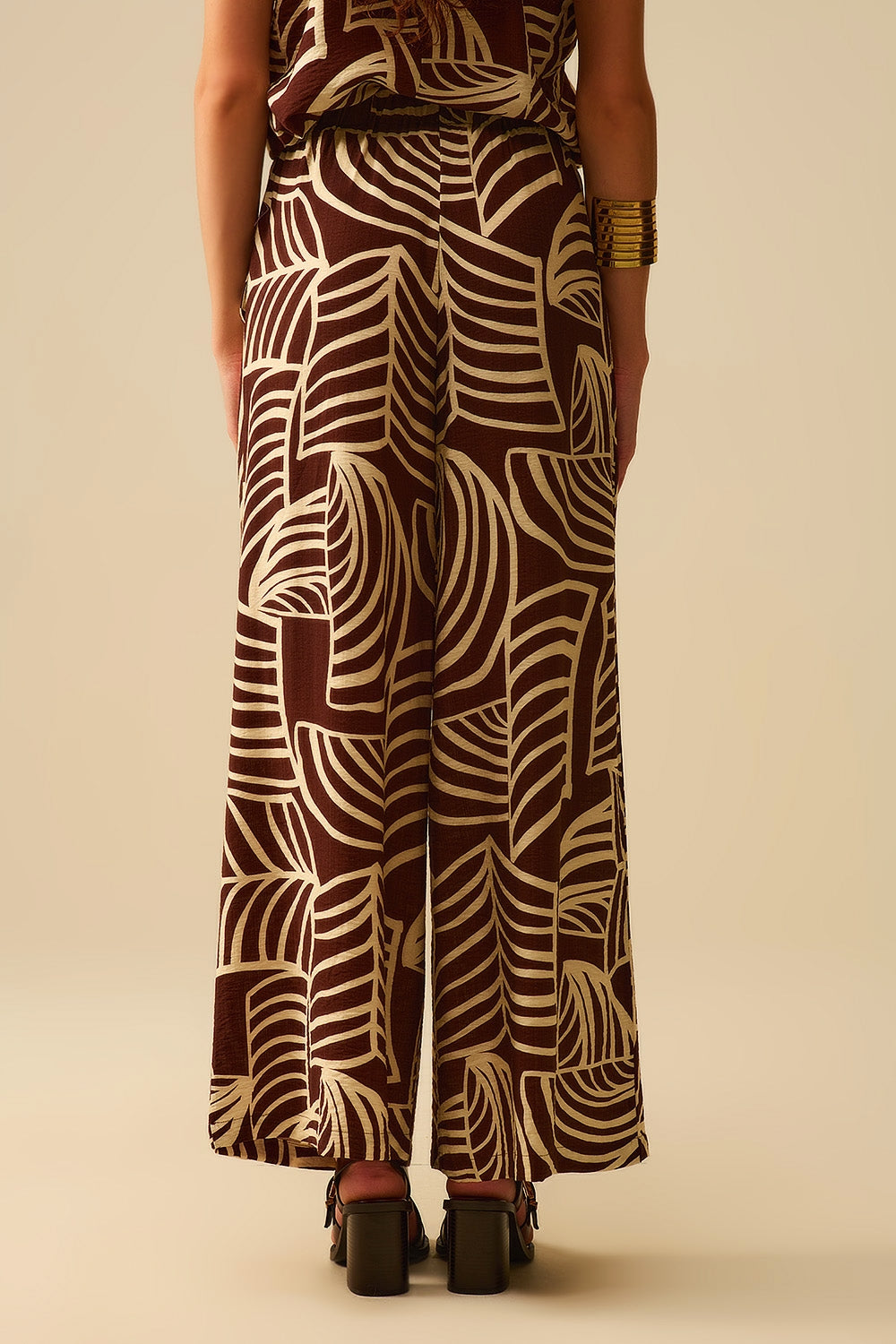 Pantalon large marron avec imprimé feuilles blanches