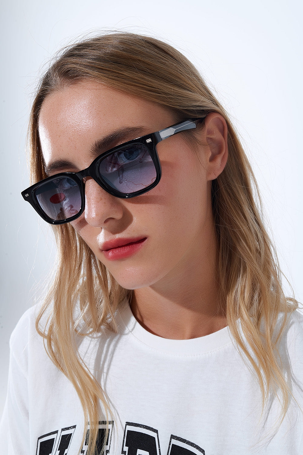 Lunettes de soleil carrées noires avec verres bleus dégradés et détails latéraux en métal