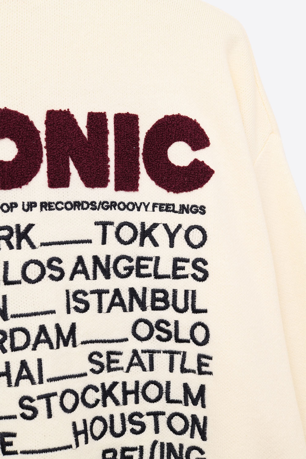 Pull ICONIC brodé avec imprimé Global Tour dans le dos en crème