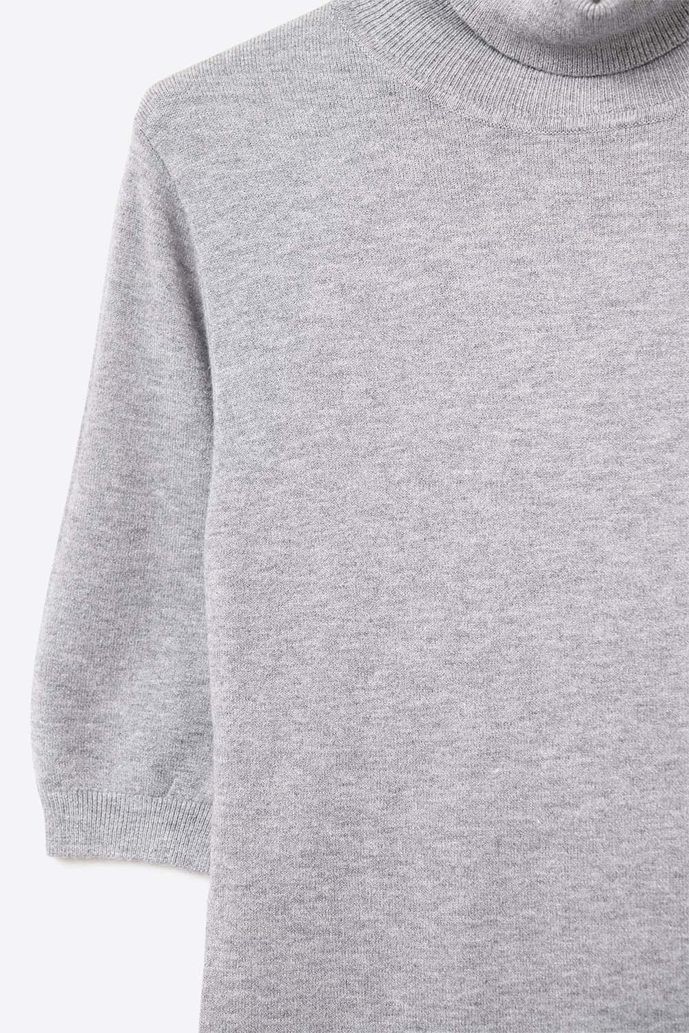 Pull en maille fine de couleur grise avec un col montant et des manches coudées