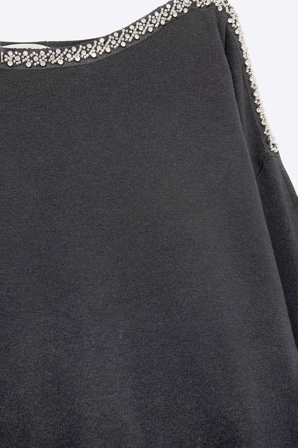 pull noir en maille fine avec un col bateau et des détails en strass