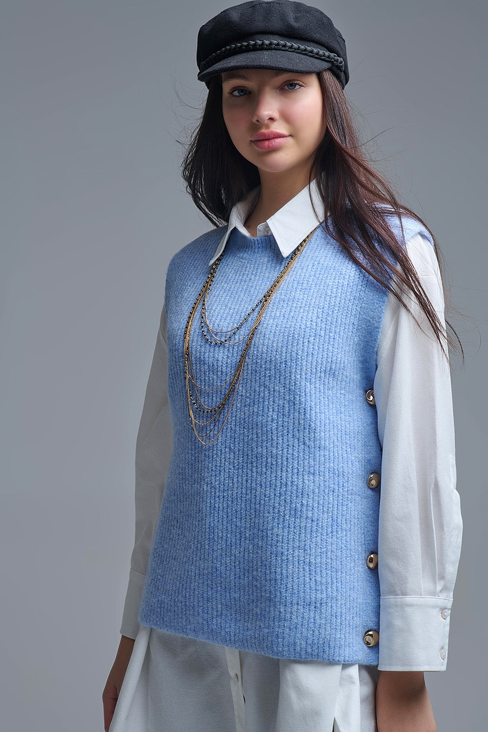 Pull bleu sans manches avec boutons dorés sur le côté