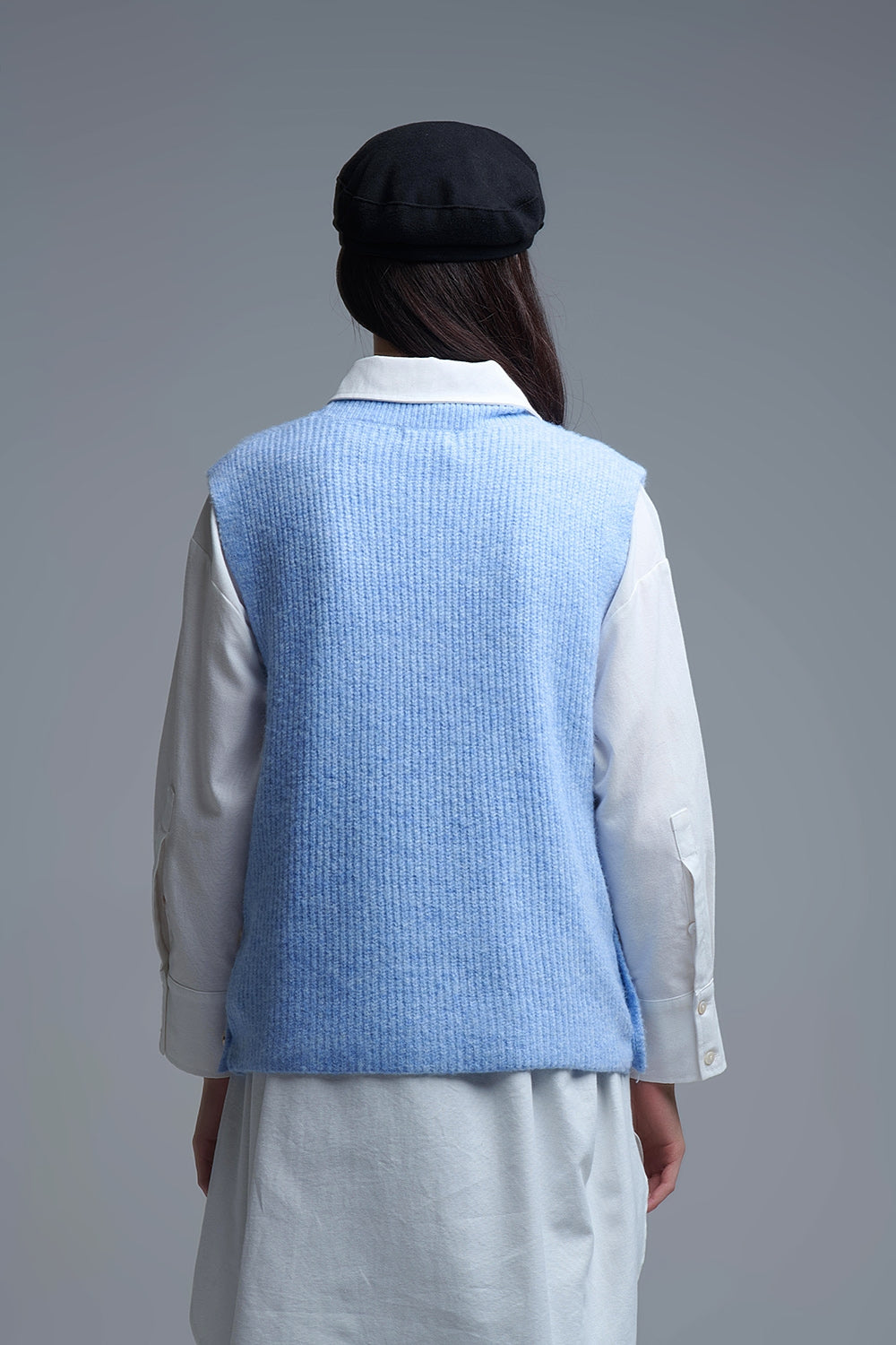 Pull bleu sans manches avec boutons dorés sur le côté
