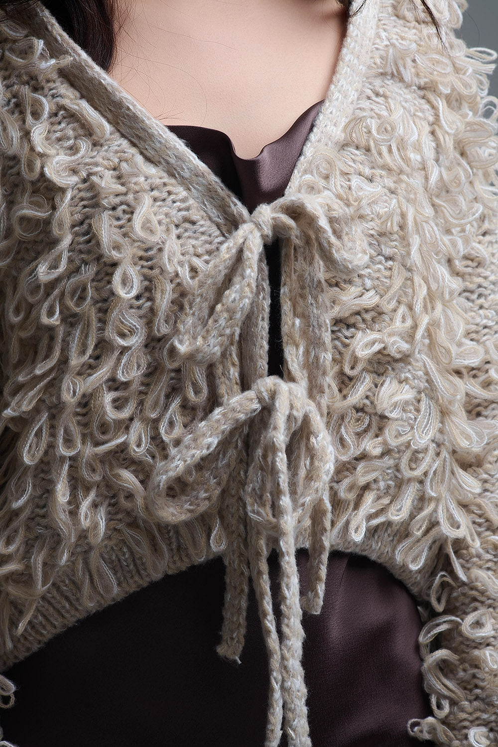 Cardigan croisé en maille épaisse beige avec col en V et fermeture à nouer sur le devant