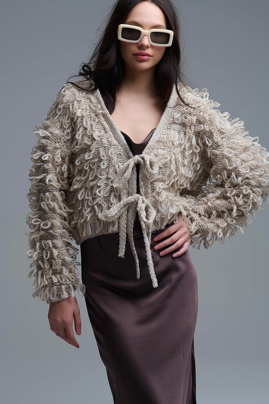 Cardigan croisé en maille épaisse beige avec col en V et fermeture à nouer sur le devant