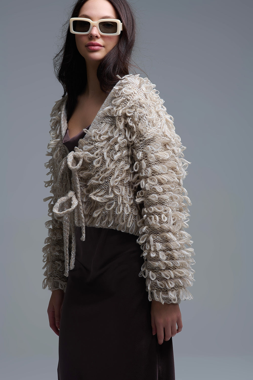 Cardigan croisé en maille épaisse beige avec col en V et fermeture à nouer sur le devant