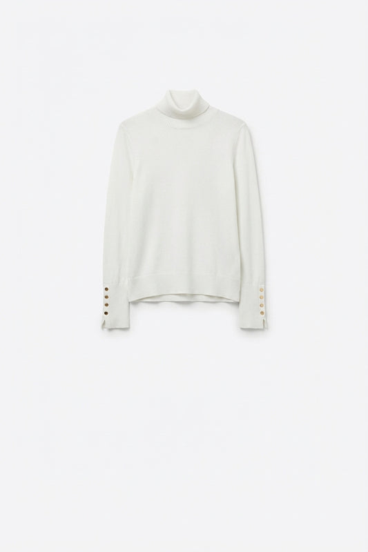 Pull à col roulé blanc avec boutons dorés sur la manchette
