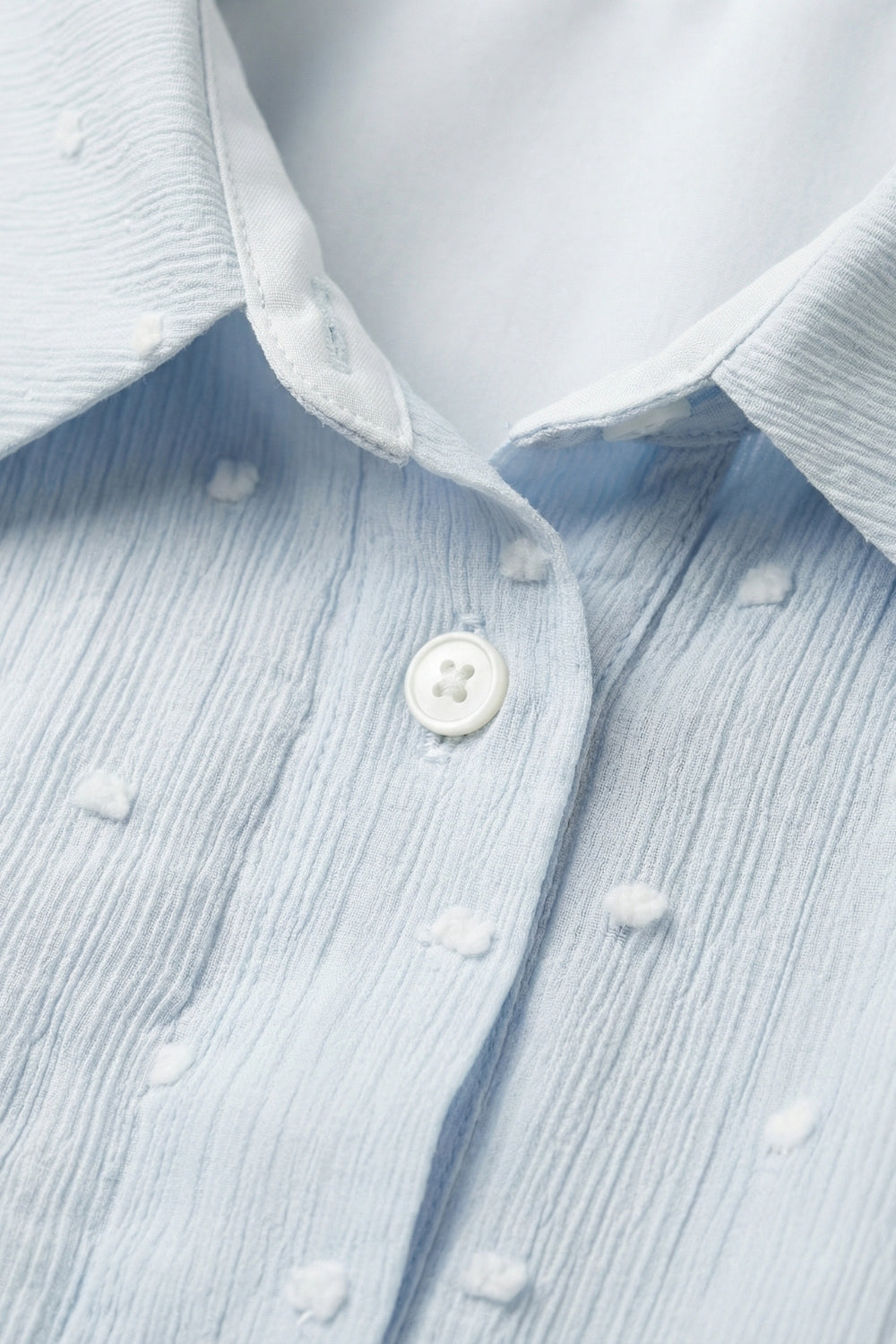 Blouse bleu clair à pois brodés avec boutons