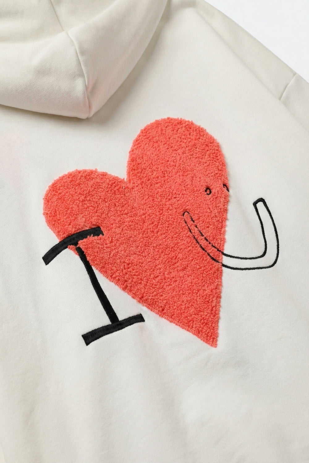 Chandail à capuchon super doux de couleur crème avec graphique en forme de cœur bouclé