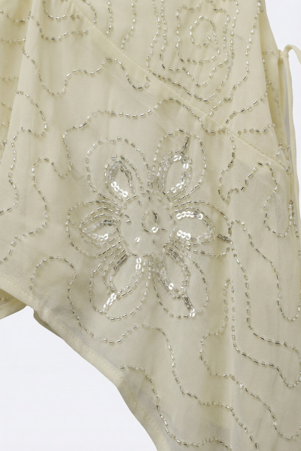 Top asymétrique en chiffon crème avec embellissement perlé